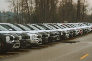 Række af nye biler parkeret på en forhandlerplads